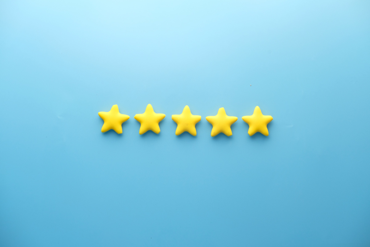 Customer Review Concept. Rating Golden Stars on Blue Background